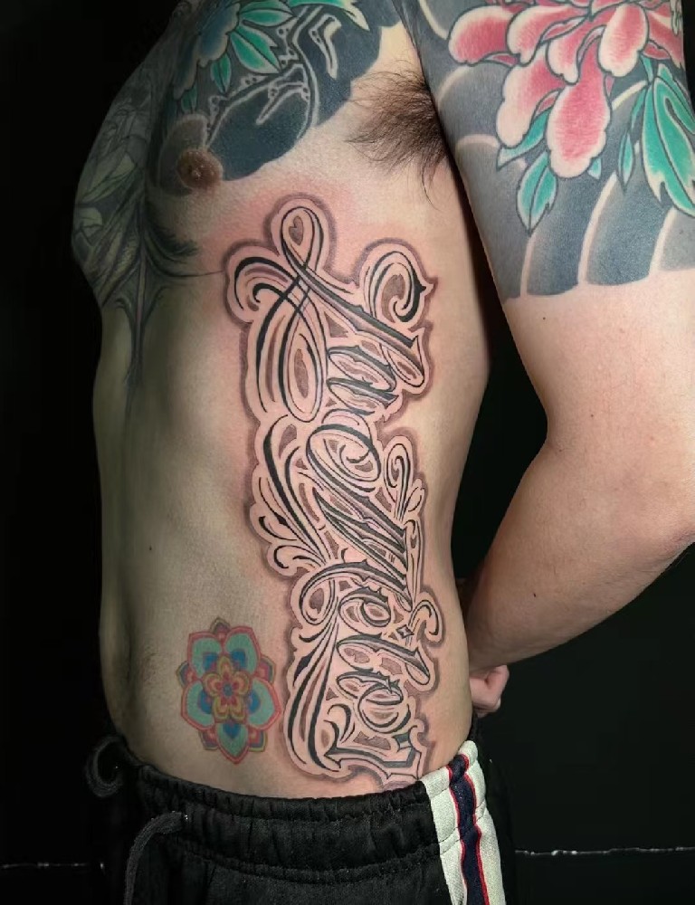 侧腰花体字纹身